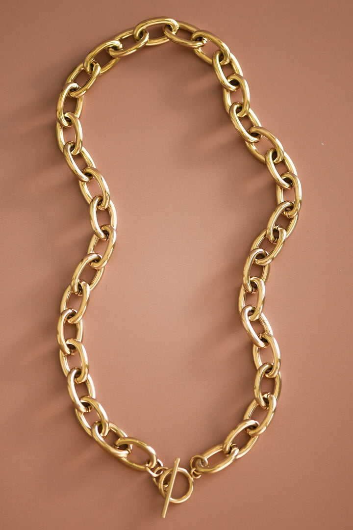 Gold chain necklace on a brown background