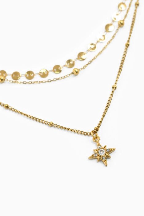 Gold necklace with star pendant on a white background