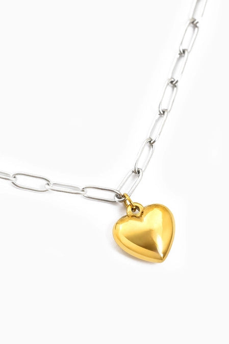 Gold heart-shaped pendant on a silver chain against a white background