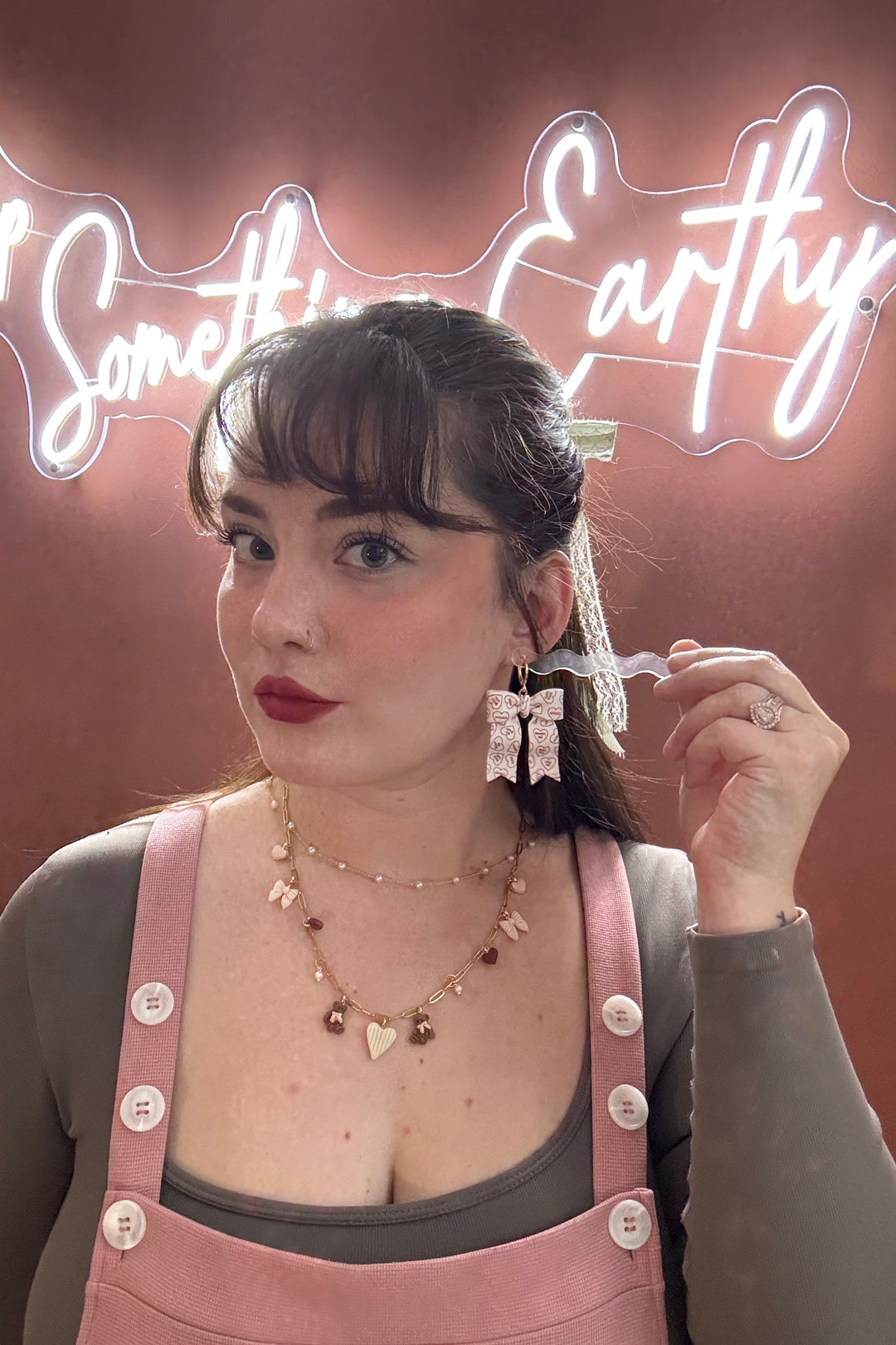 Woman holding a clear plastic bag with a neon sign in the background
