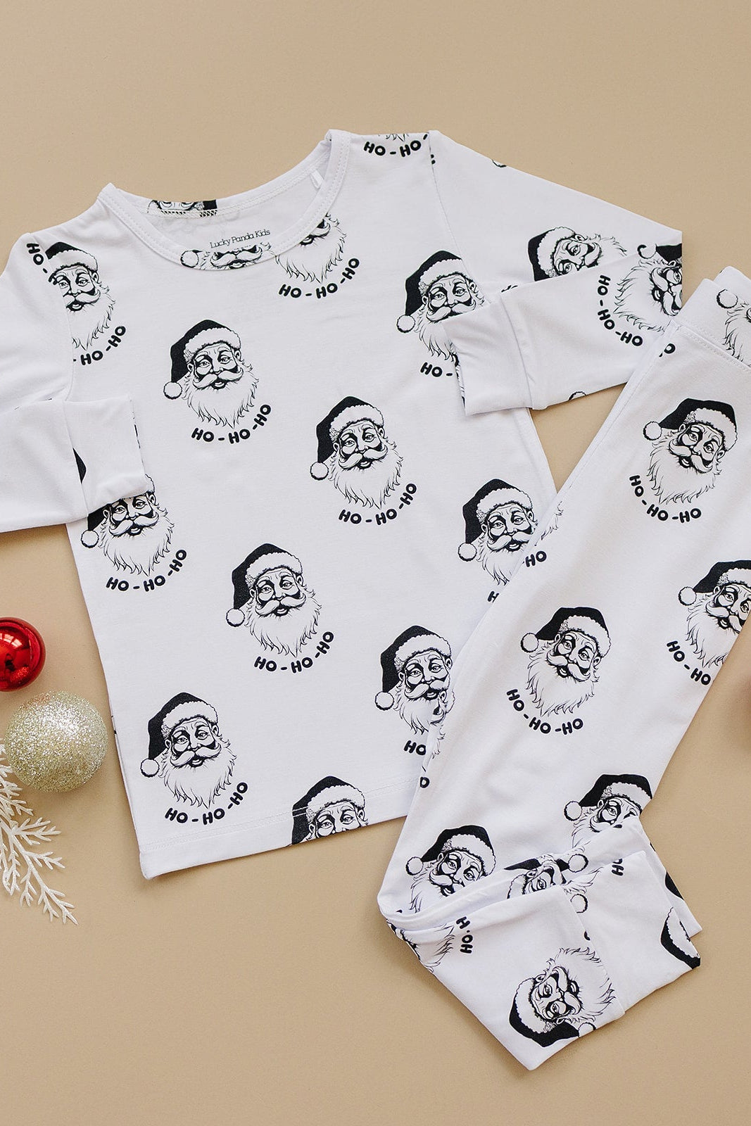 White pajama set with black Santa Claus print on a beige background