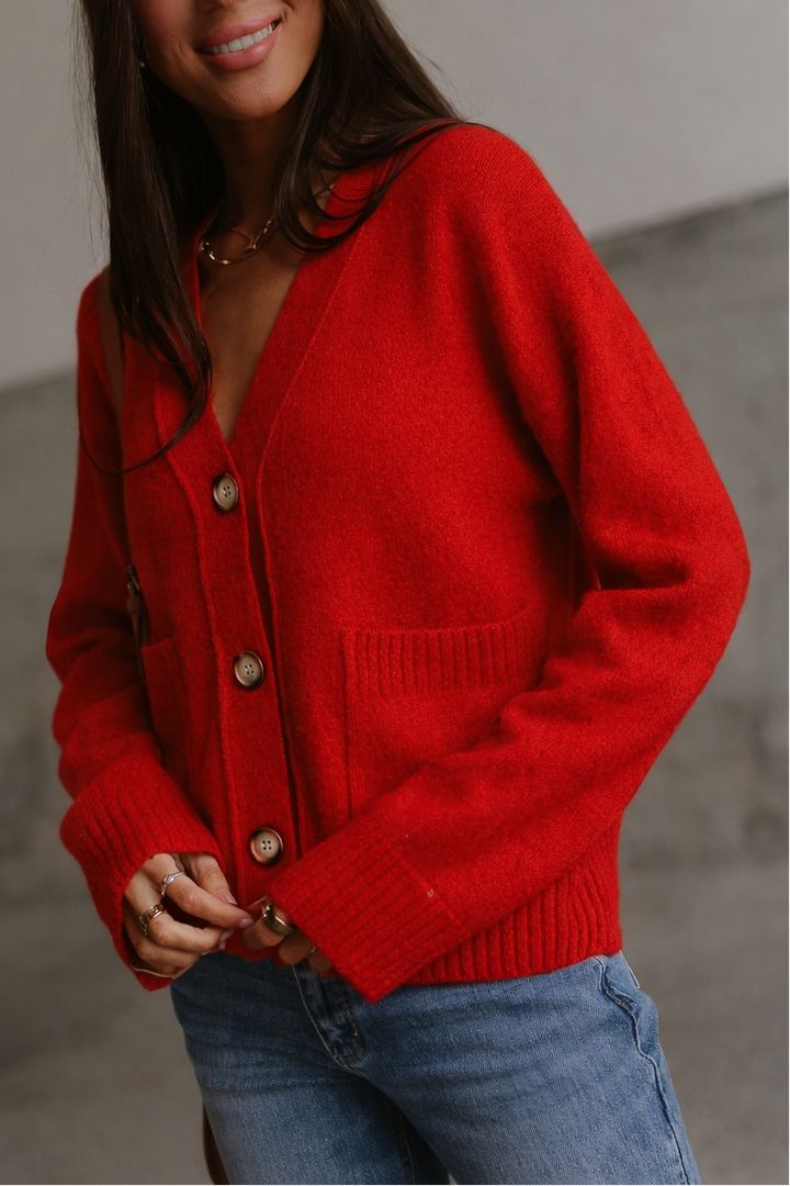 Person wearing a red cardigan with a blurred background